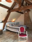 Main bedroom with King bed, exposed oak beams, and sitting area